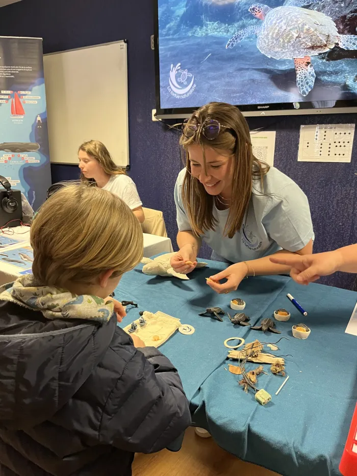Bénévole animant un atelier pédagogique autour des tortues marines